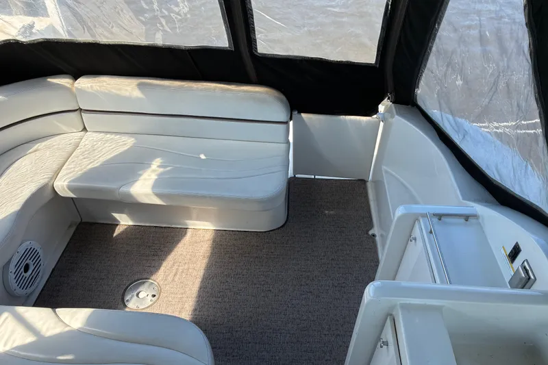 Slide: The Image of Interior of a 1999 Trojan 360 Express boat with white seating and carpeted floor. - 6