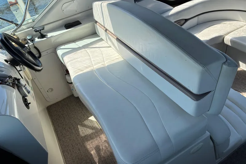 Slide: The Image of Interior of a 1999 Trojan 360 Express boat with white leather seating and steering wheel. - 9