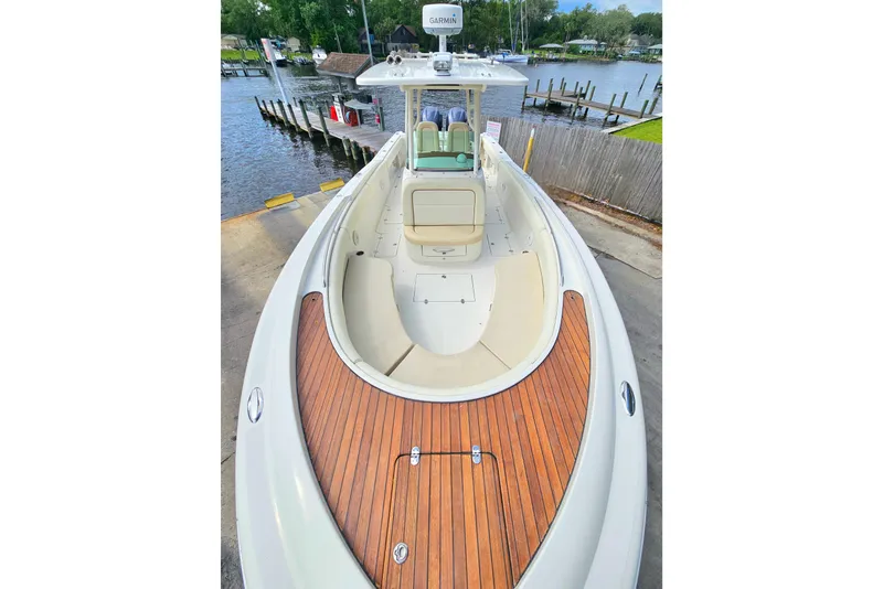 Slide: The Image of 2008 Chris-Craft Catalina 29 boat with teak deck, docked by a serene waterfront. - 11