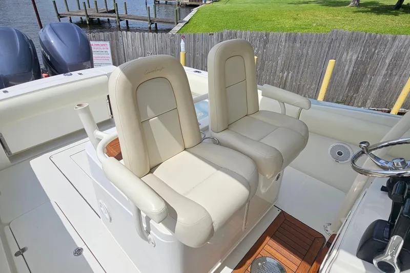 Slide: The Image of 2008 Chris-Craft Catalina 29 boat interior with dual cream seats and wooden flooring. - 15