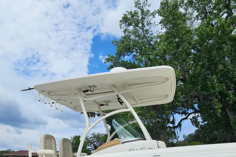 Slide: The Image of 2008 Chris-Craft Catalina 29 boat with T-top against a blue sky and trees. - 2
