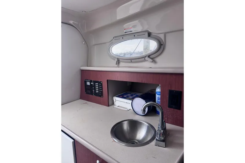 Slide: The Image of 2003 Robalo R265 Walkaround cabin interior with sink, porthole, and control panel. - 12
