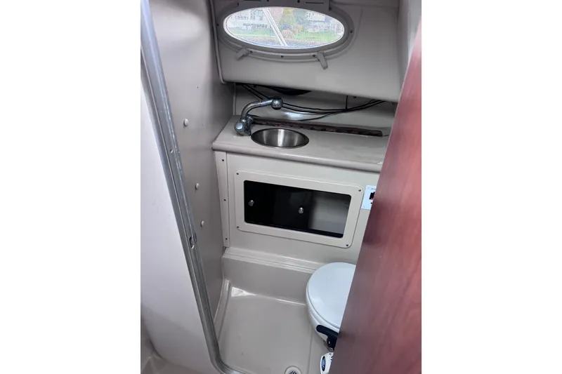 Slide: The Image of 2003 Robalo R265 Walkaround boat interior with sink and toilet in compact bathroom. - 13
