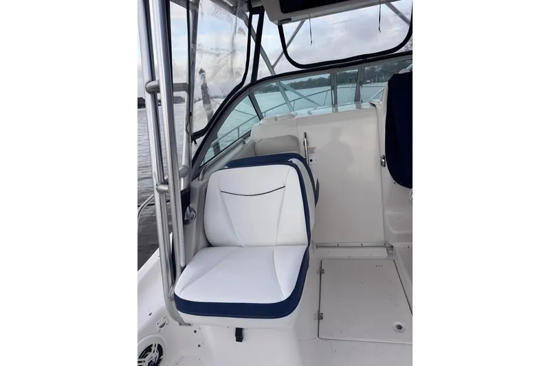 Slide: The Image of 2003 Robalo R265 Walkaround boat interior with cushioned seating and clear canopy. - 6