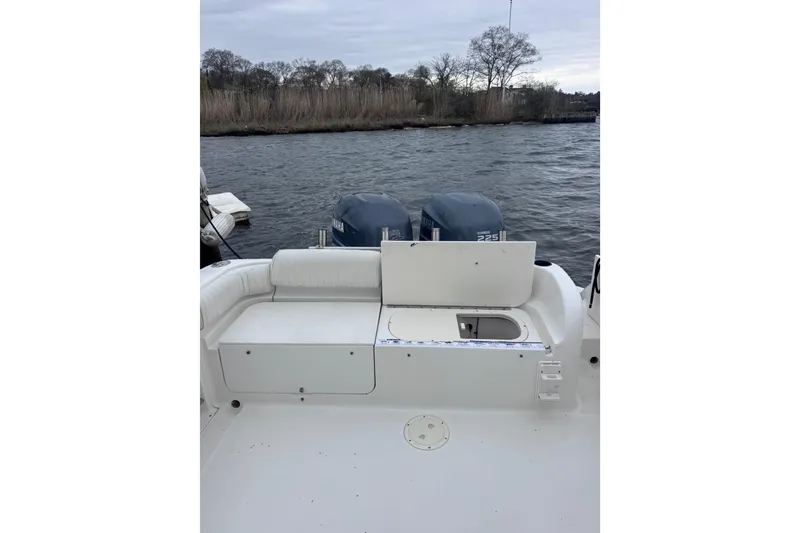 Slide: The Image of 2003 Robalo R265 Walkaround boat with twin Yamaha engines on a calm waterway. - 7