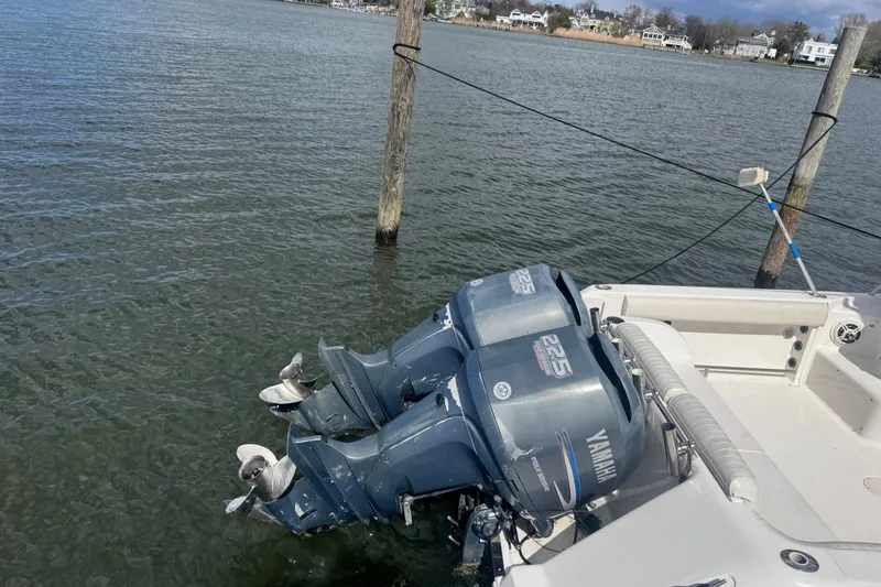 Slide: The Image of 2003 Robalo R265 Walkaround with twin Yamaha 225 outboard motors docked on calm water. - 8