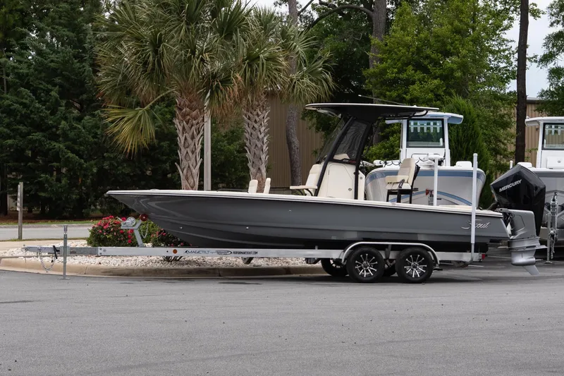 The Image of 2026 Scout 231 XSB boat on trailer, parked near palm trees. - 1
