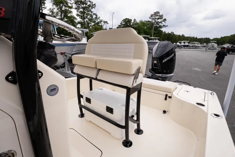 Slide: The Image of 2026 Scout 231 XSB boat interior with seating and Mercury engine in a marina setting. - 10