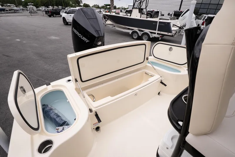 Slide: The Image of 2026 Scout 231 XSB boat with open storage compartments and Mercury engine. - 13