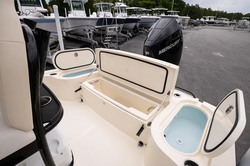 Slide: The Image of 2026 Scout 231 XSB boat with open storage compartments and Mercury engine. - 14