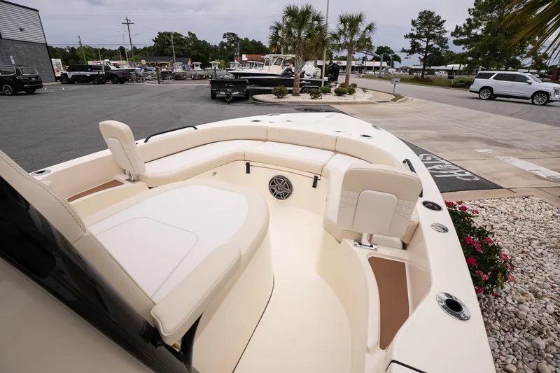 Slide: The Image of 2026 Scout 231 XSB boat with spacious seating, parked outdoors near palm trees. - 16