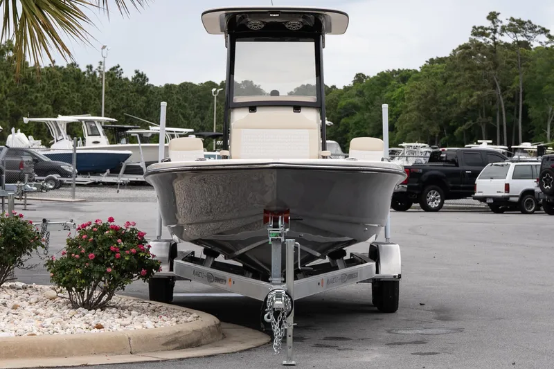 Slide: The Image of 2026 Scout 231 XSB boat on trailer in parking lot, surrounded by greenery. - 3