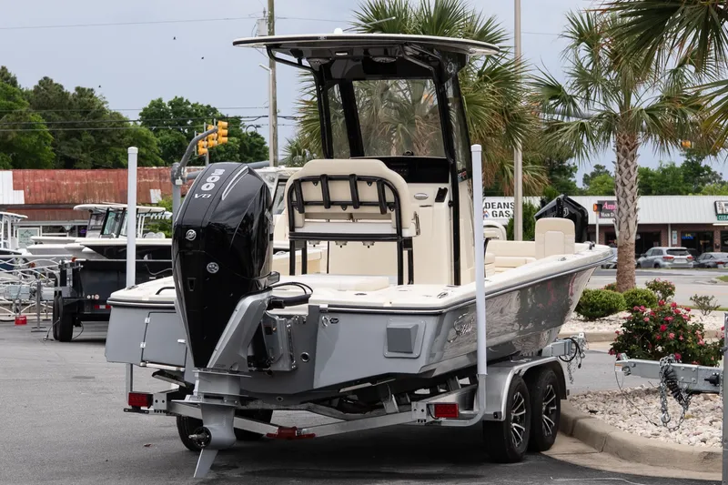 Slide: The Image of 2026 Scout 231 XSB boat on trailer with powerful outboard motor in a parking lot. - 6
