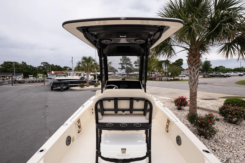 Slide: The Image of 2026 Scout 231 XSB boat interior with helm, parked near palm trees. - 7