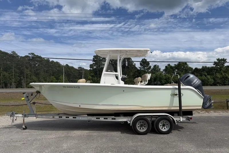 The Image of 2018 Sea Hunt Ultra 225 boat on trailer, parked outdoors under cloudy sky. - 1