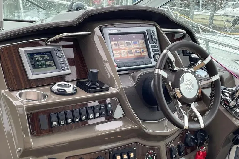 Slide: The Image of Helm of 2012 Cruisers Yachts 380 Express with navigation controls and steering wheel. - 15
