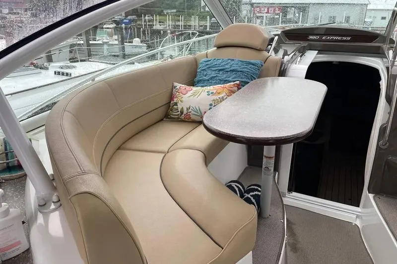 Slide: The Image of 2012 Cruisers Yachts 380 Express interior with beige seating and decorative pillows. - 16
