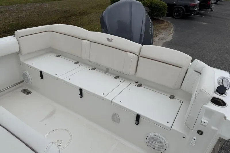 Slide: The Image of 2018 Sea Hunt Ultra 255 SE boat interior with white cushioned seating and storage compartments. - 13