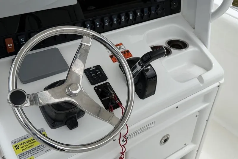Slide: The Image of Steering console of 2018 Sea Hunt Ultra 255 SE boat with controls and cup holder. - 23