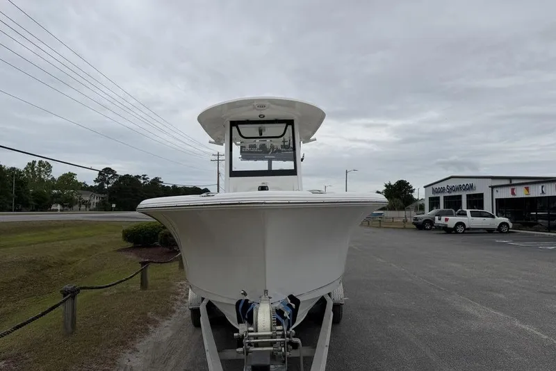 Slide: The Image of 2018 Sea Hunt Ultra 255 SE boat on trailer, parked near showroom under cloudy sky. - 9