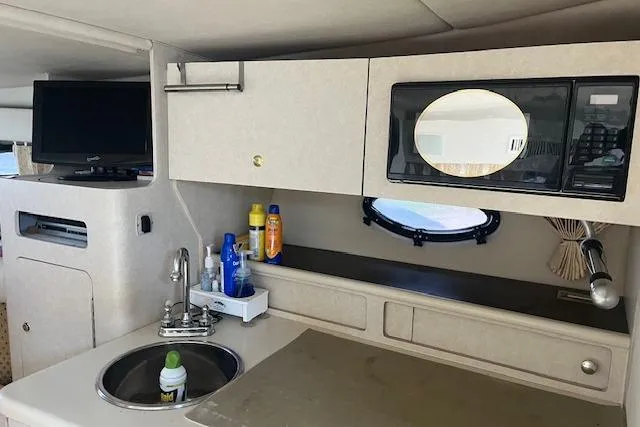 Slide: The Image of 1997 Regal Commodore 322 yacht interior with kitchenette, sink, and microwave. - 14