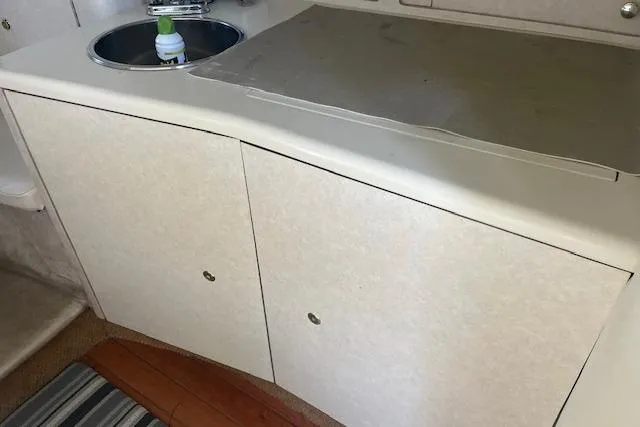 Slide: The Image of 1997 Regal Commodore 322 boat interior with sink and storage cabinets. - 15