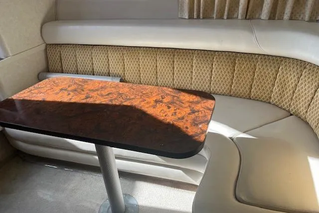 Slide: The Image of 1997 Regal Commodore 322 interior with wood table and cushioned seating. - 19