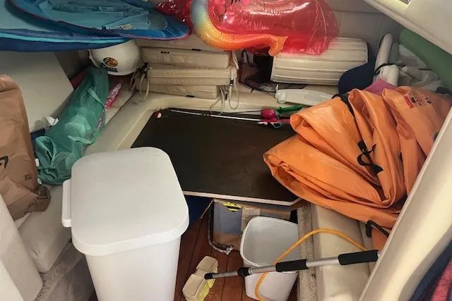 Slide: The Image of Interior of a 1997 Regal Commodore 322 boat cluttered with various items and equipment. - 21