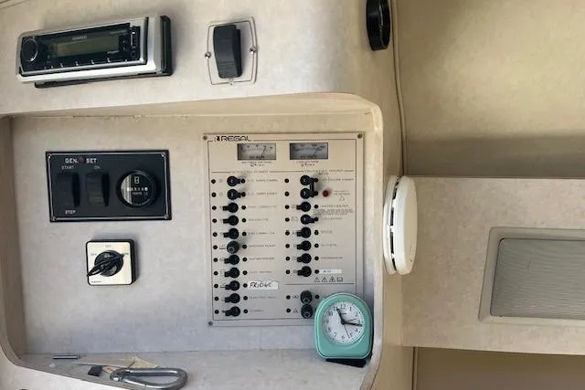 Slide: The Image of Control panel of a 1997 Regal Commodore 322 boat with switches and a clock. - 22