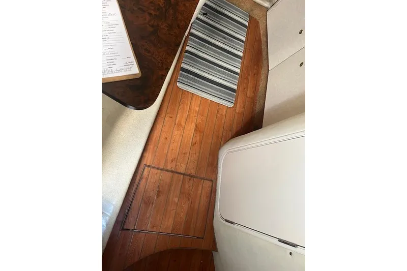 Slide: The Image of Interior of a 1997 Regal Commodore 322 boat with wooden flooring and striped rug. - 24