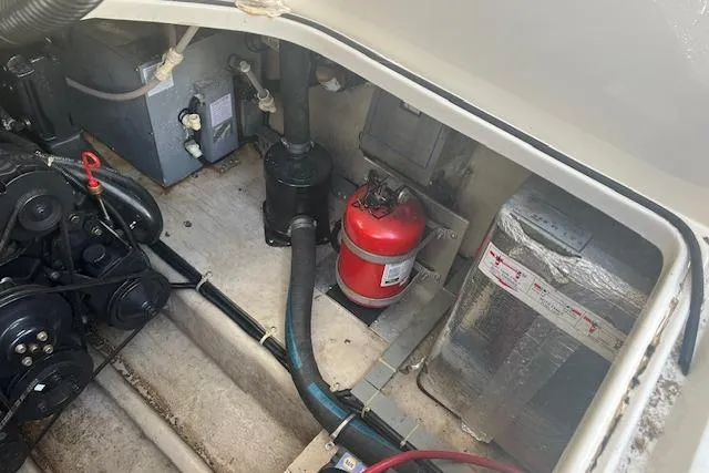 Slide: The Image of Engine compartment of 1997 Regal Commodore 322 with fire extinguisher and mechanical components. - 27