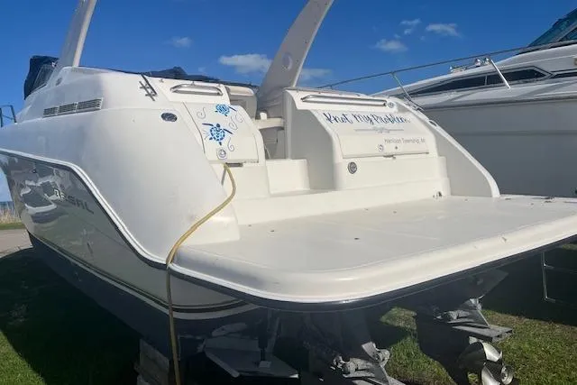 Slide: The Image of 1997 Regal Commodore 322 boat with white exterior, docked on grass under a clear blue sky. - 3