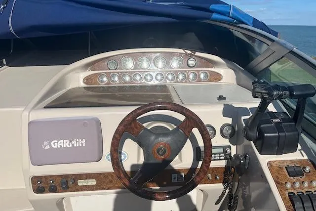 Slide: The Image of 1997 Regal Commodore 322 boat dashboard with Garmin navigation system and wood-trimmed steering wheel. - 6