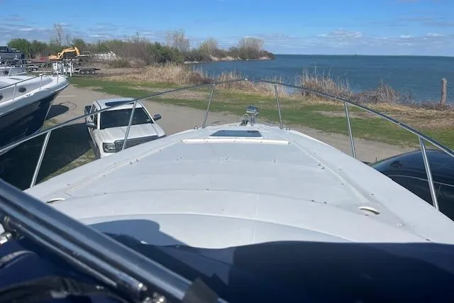 Slide: The Image of 1997 Regal Commodore 322 boat docked near a lake with clear skies. - 8