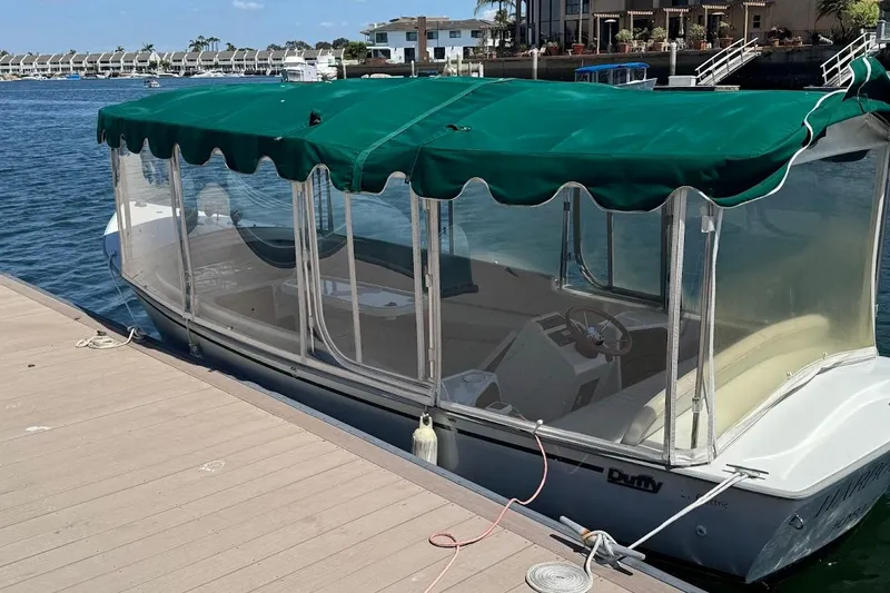 Slide: The Image of 2001 Duffy Classic 21 electric boat docked with green canopy and clear side panels. - 5