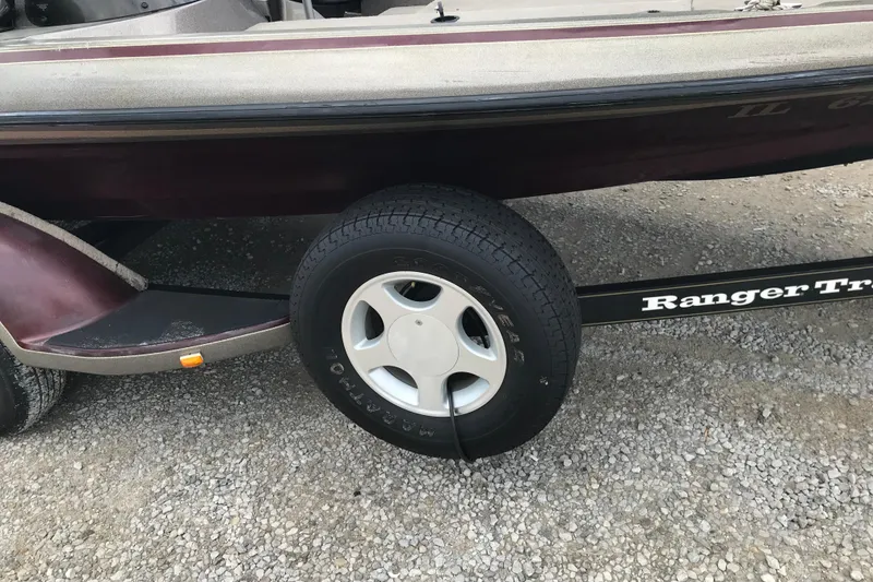 Slide: The Image of 2001 Ranger 518DVX Comanche boat trailer with Goodyear tire on gravel. - 17