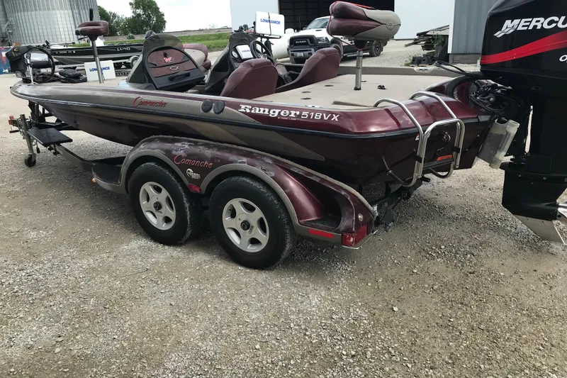 Slide: The Image of 2001 Ranger 518DVX Comanche boat with dual axle trailer, parked outdoors. - 4