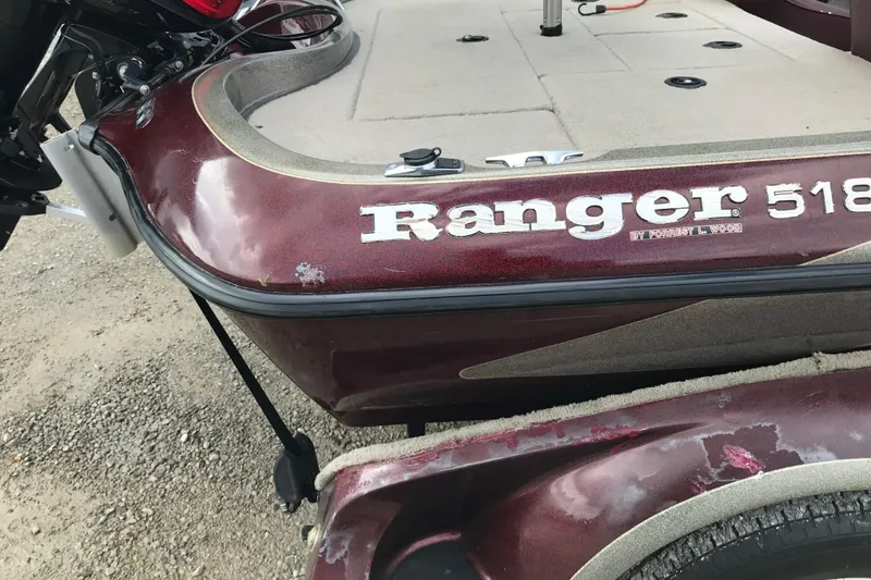 Slide: The Image of 2001 Ranger 518DVX Comanche boat with maroon finish and visible wear. - 41