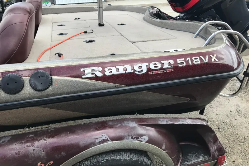 Slide: The Image of 2001 Ranger 518DVX Comanche boat, maroon color, with visible seating and motor. - 46
