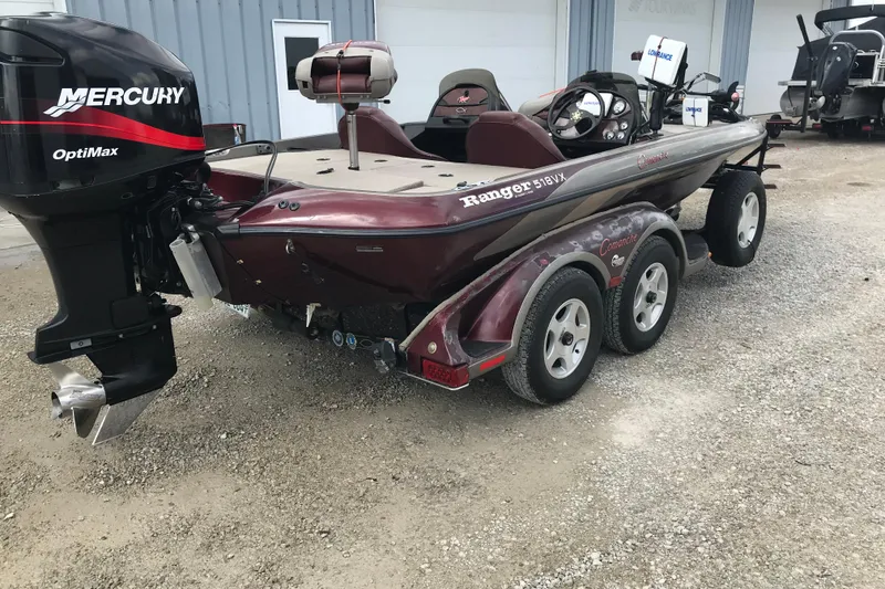 Slide: The Image of 2001 Ranger 518DVX Comanche boat with Mercury OptiMax engine, parked on gravel. - 5