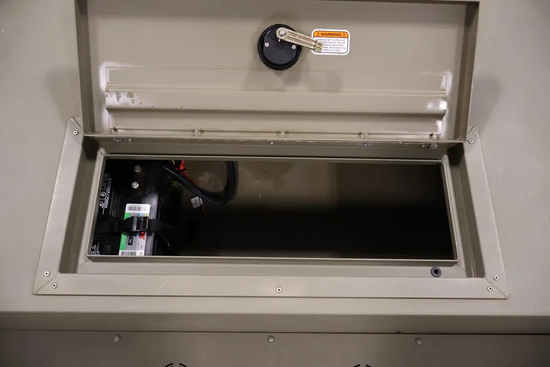 Slide: The Image of Open storage compartment of 2023 Tracker Grizzly 1860 MVX CC boat, showing battery inside. - 15