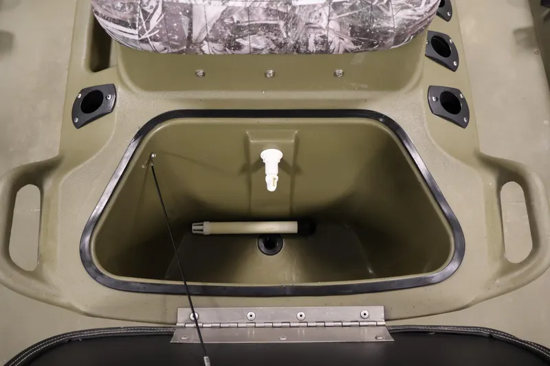 Slide: The Image of 2023 Tracker Grizzly 1860 MVX CC boat storage compartment with camo seat and rod holders. - 19