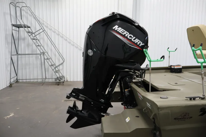 Slide: The Image of 2023 Tracker Grizzly 1860 MVX CC boat with Mercury outboard motor in a garage. - 34
