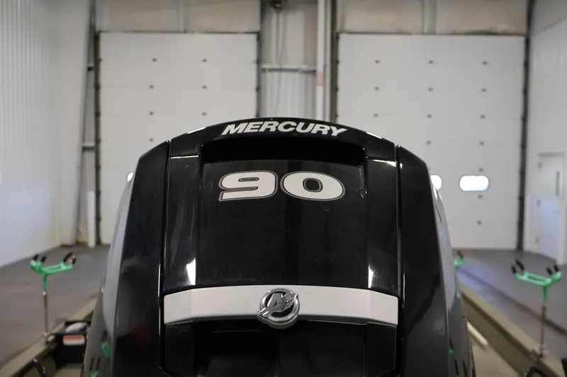 Slide: The Image of 2023 Tracker Grizzly 1860 MVX CC with Mercury 90 engine in a garage. - 35