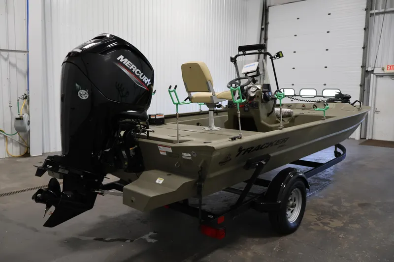 Slide: The Image of 2023 Tracker Grizzly 1860 MVX CC boat with Mercury engine in a garage setting. - 4