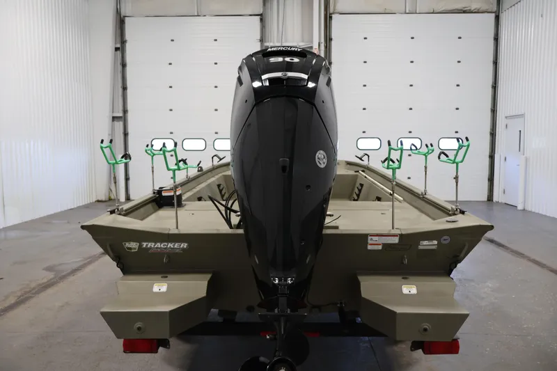 Slide: The Image of 2023 Tracker Grizzly 1860 MVX CC boat with Mercury engine in a garage setting. - 5