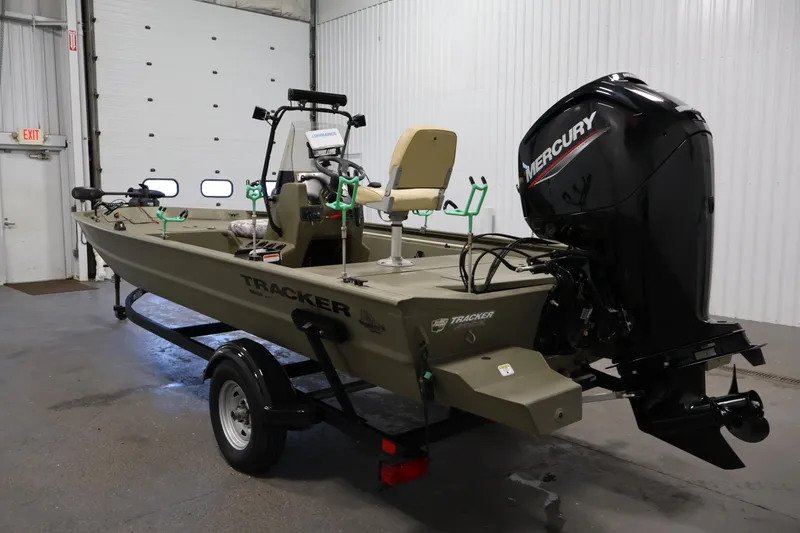 Slide: The Image of 2023 Tracker Grizzly 1860 MVX CC boat with Mercury engine in a garage setting. - 6