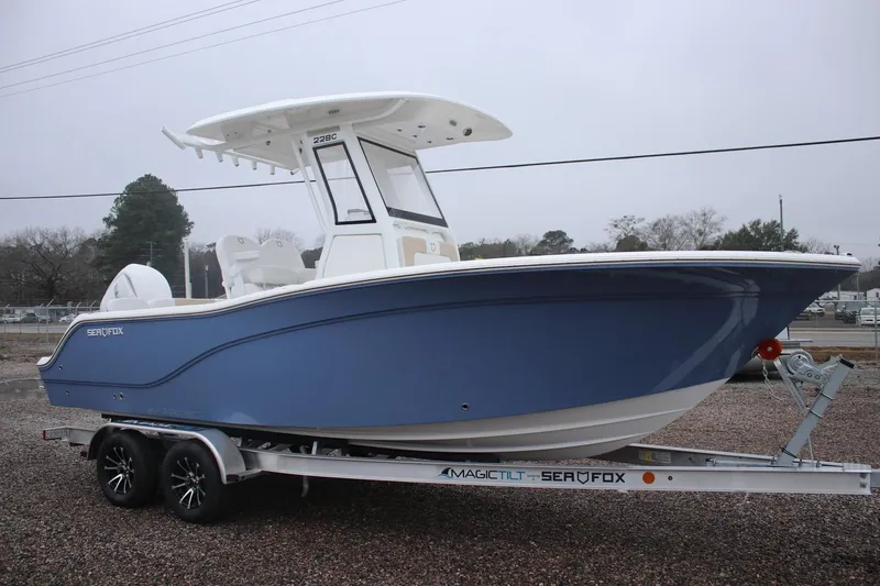 Slide: The Image of 2026 Sea Fox 228 Commander boat on trailer, blue hull, overcast day. - 2
