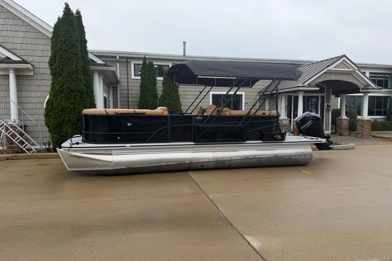 The Image of 2025 Crest Classic 220 pontoon boat parked outside a modern building. - 0