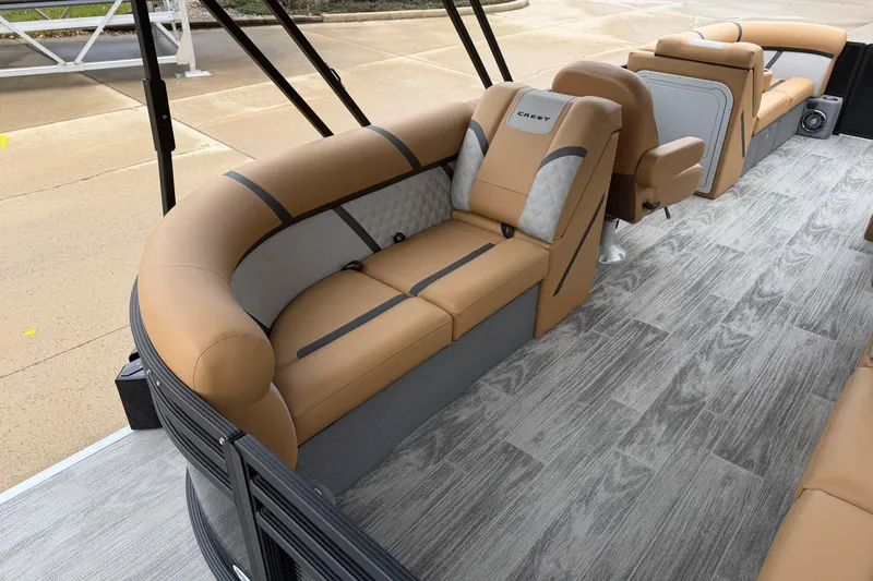 Slide: The Image of Luxurious interior of 2025 Crest Classic 220 pontoon boat with tan seating and wood-style flooring. - 13